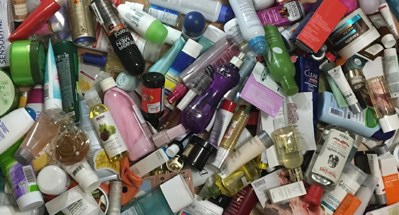 девушка рассматривает много банок с косметикой на полке