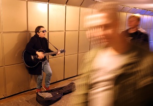 В подземном переходе. Уличные музыканты играют и поют в переходе.