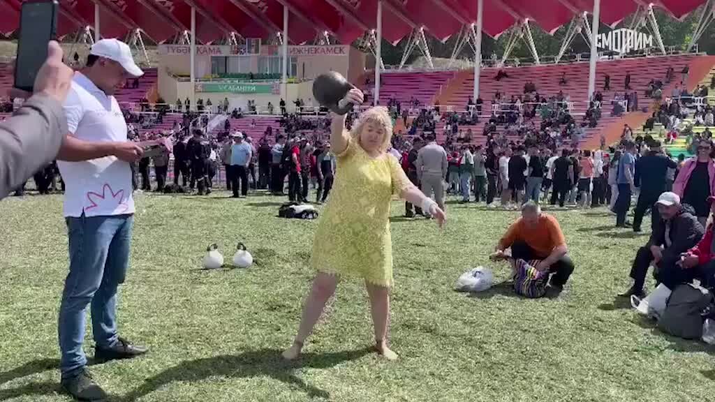 Поднятие гири женщины в спорте