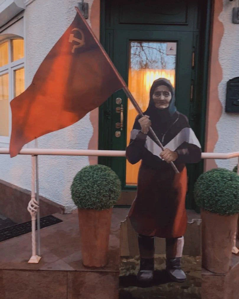 Красный выносить. Бабушка в Мариуполе с красным флагом. Памятник бабушке с красным флагом в Мариуполе. Бабушка с флагом СССР на Украине 2022. Бабушка с советским флагом.