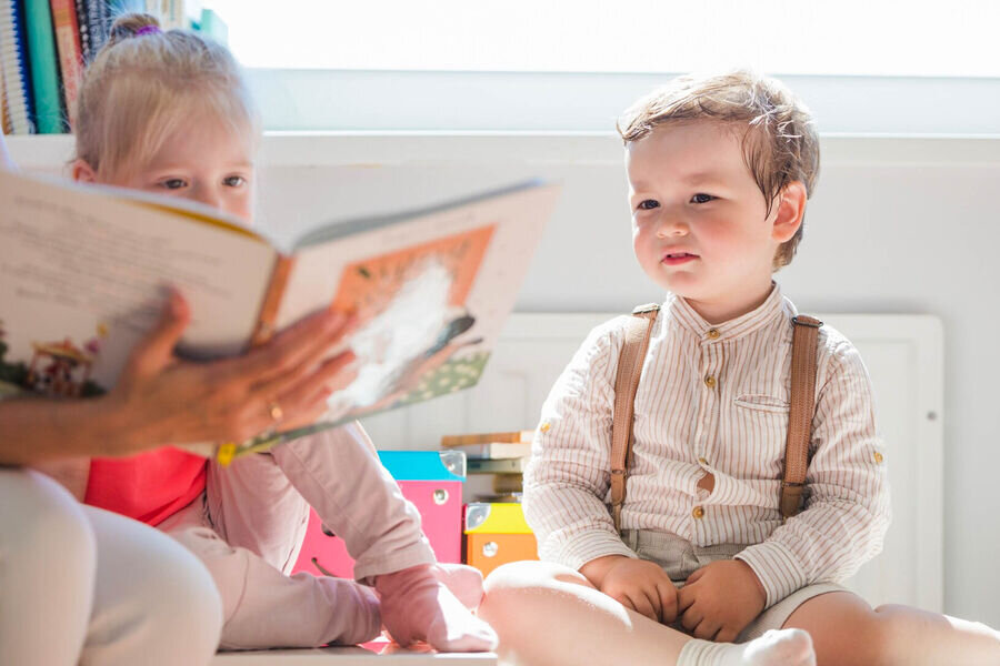 Фото детей садик с книгой. Ребенок сидит с книгой с открытыми глазами фото. Детский сад читает русский язқк. Угадайте дети с какого садика фото.