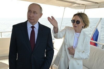    Президент РФ Владимир Путин и заместитель генерального директора компании "Газпром нефть", генеральный директор ООО "Газпром Лахта" Елена Илюхина наблюдают за церемонией подъёма государственных флагов Российской Федерации, СССР и Российской империи на береговой линии у парка 300-летия Санкт-Петербурга. ©Павел Лисицын РИА Новости