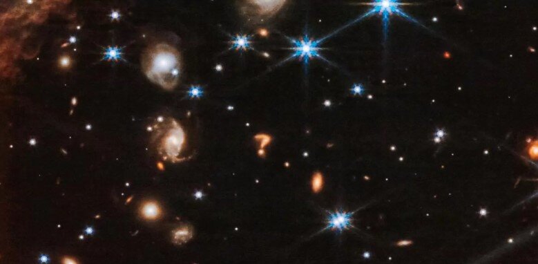 На последних снимках, полученных телескопом Джеймс Уэбб, ученые  обнаружили нечто удивительное - фоновый объект, сильно напоминающий  гигантский вопросительный знак. Но что же это такое?
