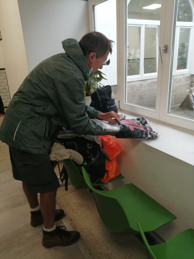 Упаковка рюкзака после складывания Компостел, полученных в офисе пилигримов в Сантьяго 