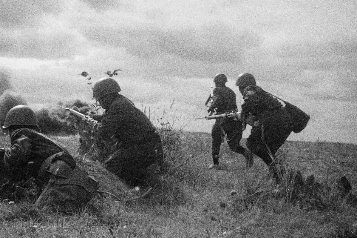 Советские солдаты идут в атаку по полю.