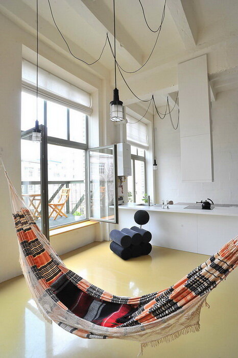 Удобный гамак с подушками в стильном номере. Дизайн интерьера