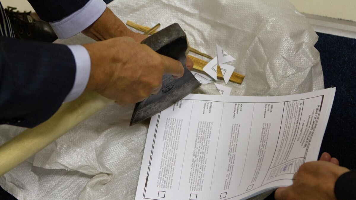    Сотрудники избирательного участка в Томске уничтожают неиспользованные бюллетени после завершения голосования на досрочных выборах губернатора области© РИА Новости / Яков Андреев