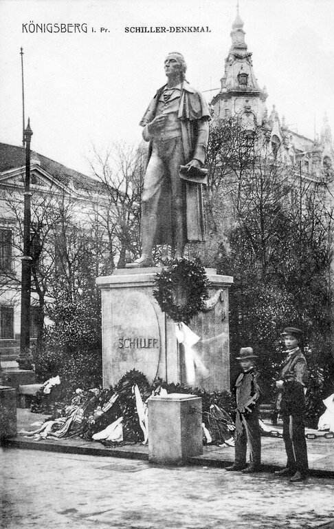 Открытка с памятником Шиллеру. Около 1910 года. 
Автор — Herausgeber: Landsmannschaft Ostpreußen, Dr Husen, freies Archiv, alte Postkarte. Лицензия — Creative Commons Attribution-Share Alike 3.0 Unported, wikimedia.org.