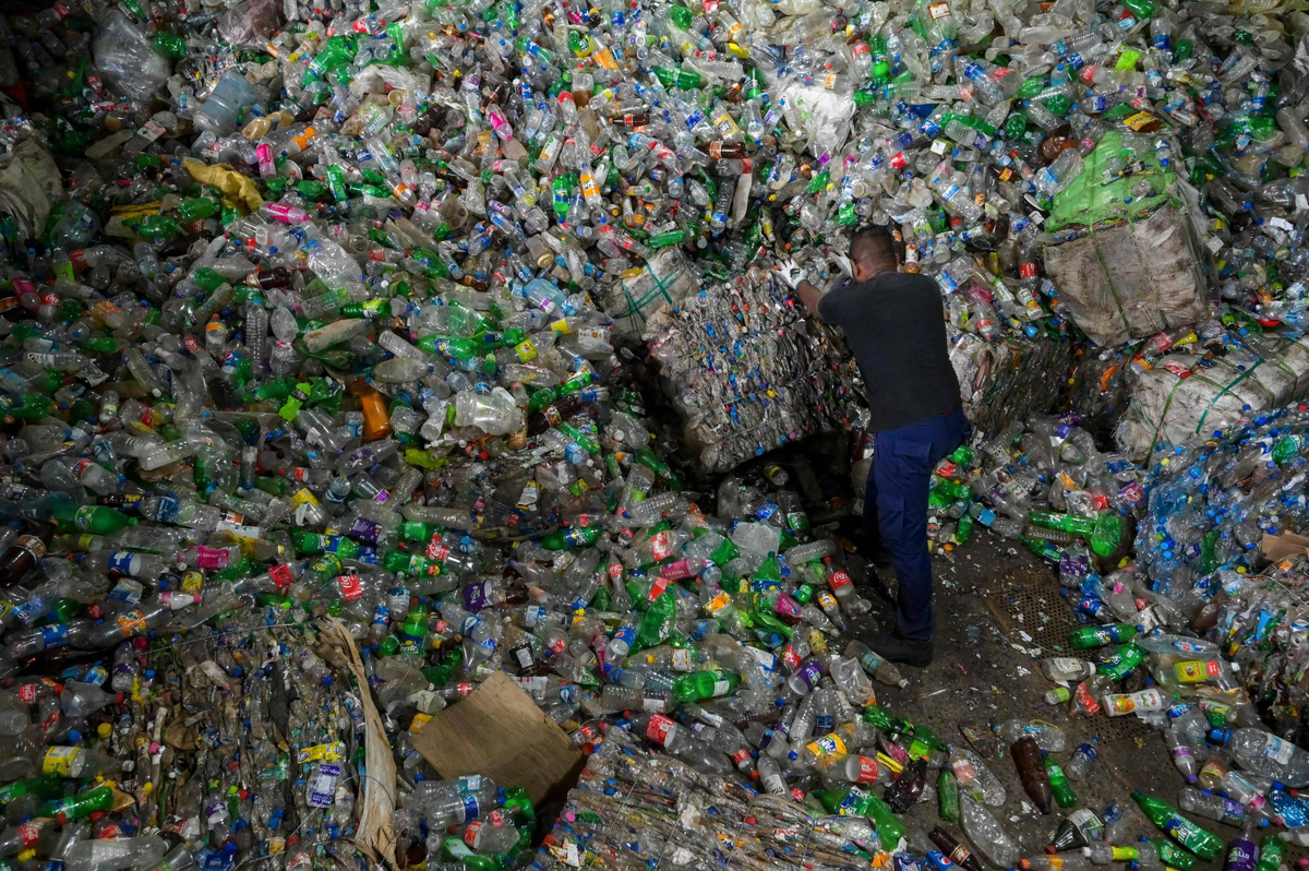 Рабочий сортирует пластиковые бутылки на крупнейшем в Шри-Ланке заводе по переработке пластика Eco Spindles в Хоране, 16 июня. AFP-JIJI