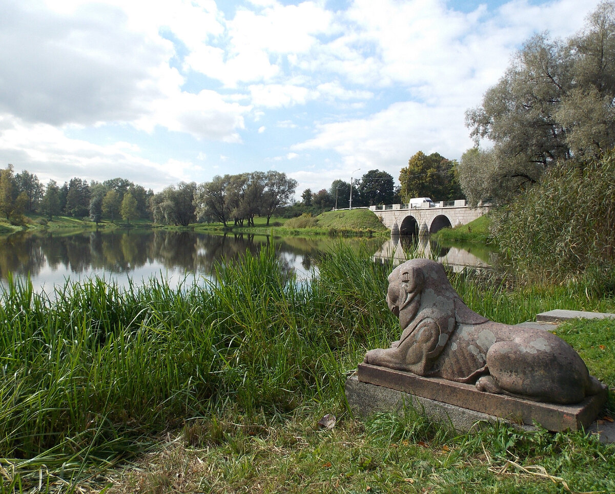 Статуя льва у подножия Трельяжной лестницы с видом на Большой каменный мост Ф. В. Бауэра в Павловске