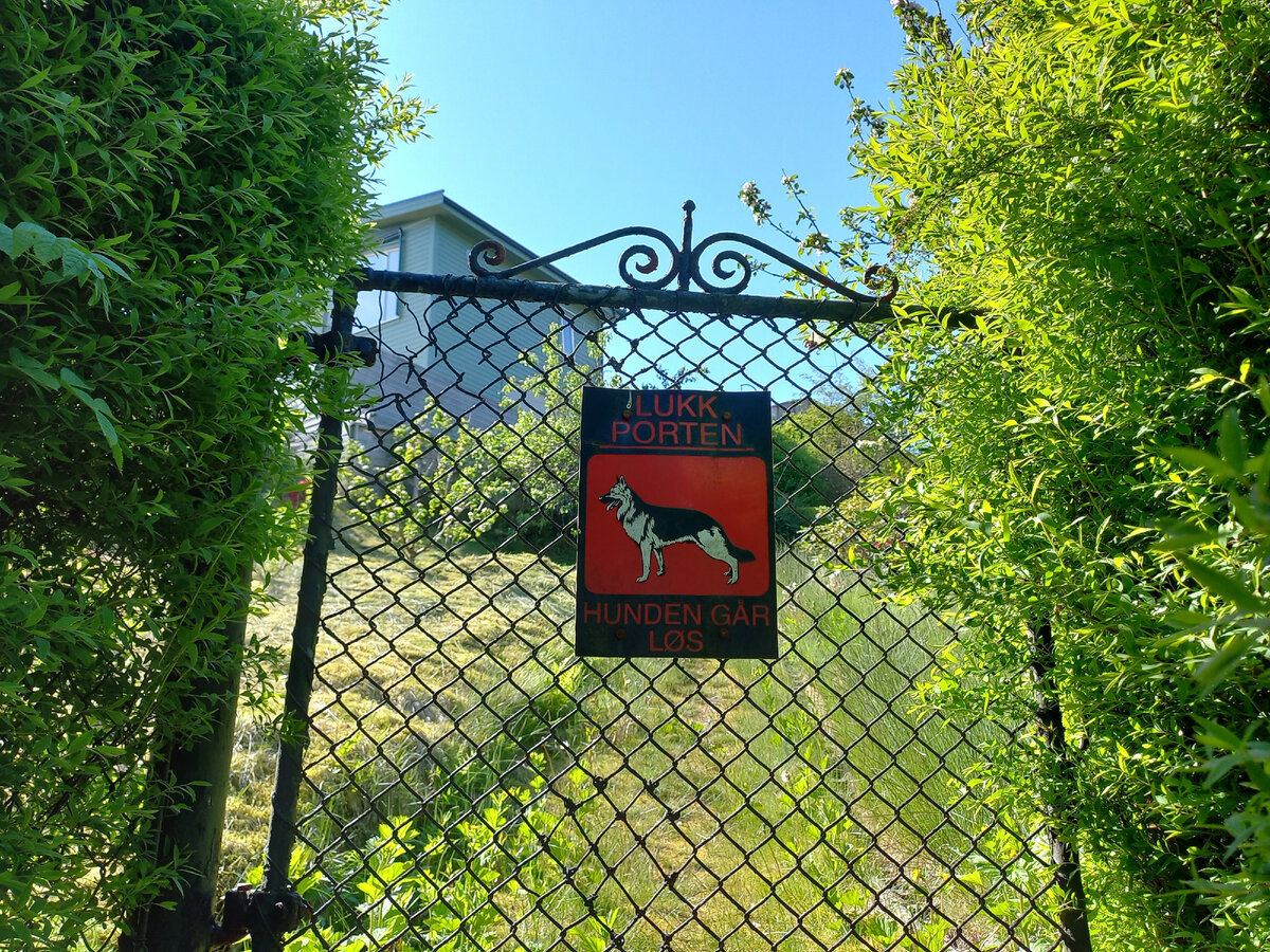 На табличке - стандартная надпись по-норвежски"Закрывайте за собой ворота. Собака может убежать."