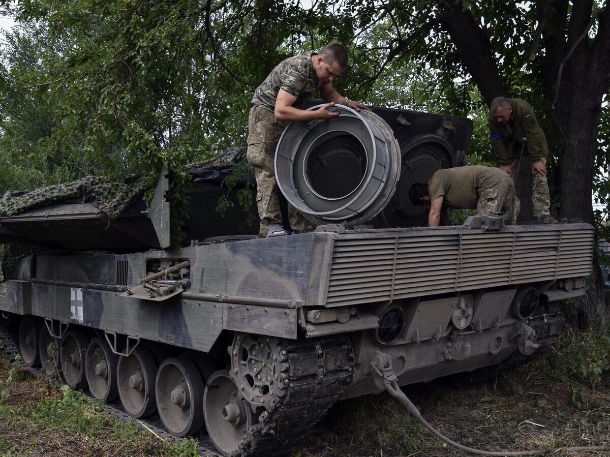     Украинские солдаты ремонтируют танк "Леопард-2" на позиции в Запорожской области© AP Photo / Andriy Andriyenko