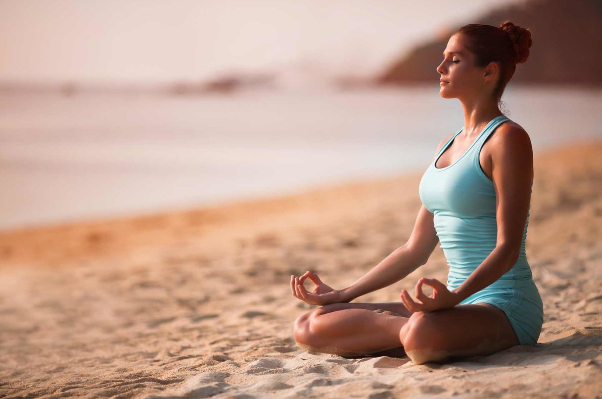 Девушка медитирует. Йога на пляже. Девушка медитирует на берегу. Девушка в позе лотоса.