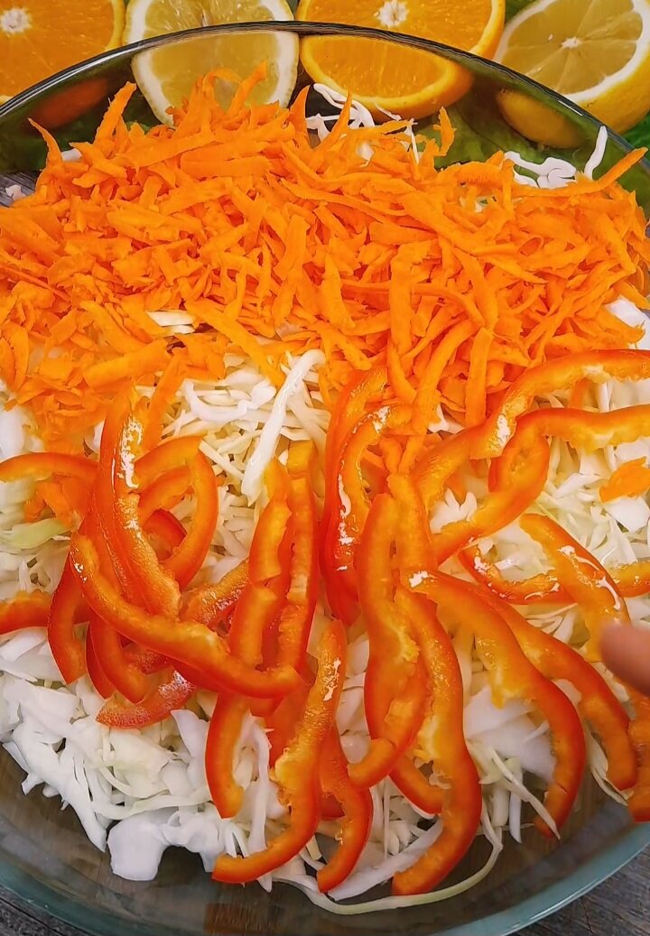 2. К нашинкованной капусте добавляем морковь натертую на крупной тёрке, чеснок  и сладкий перец(он придаст особый вкус). Перемешаем ингредиенты.