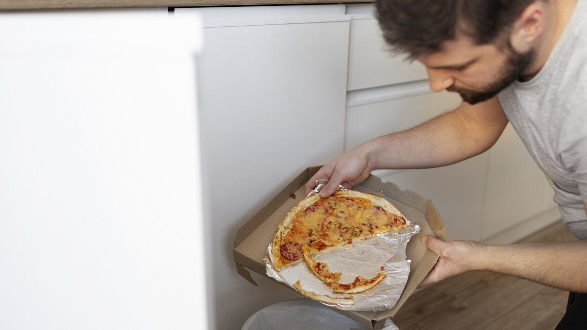    Мужчина выкидывает пиццу