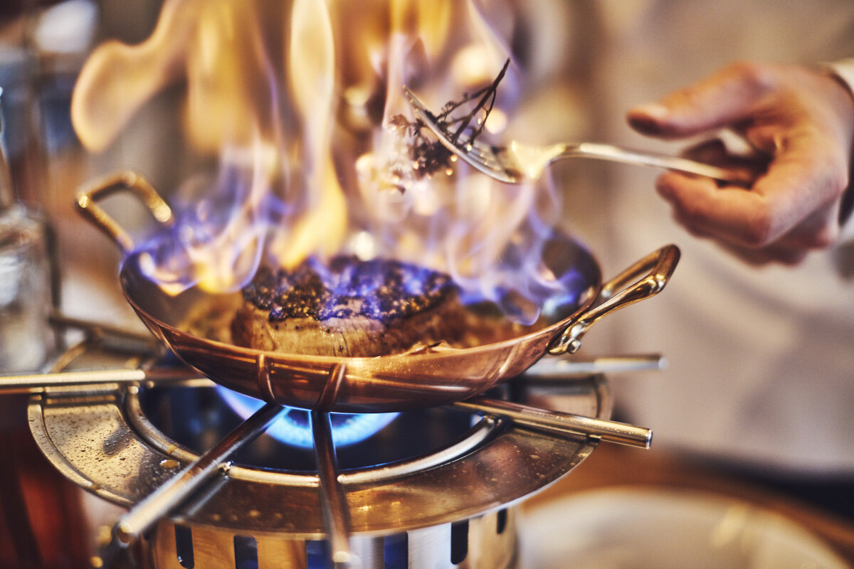 Считается что блюдо это появилось по ошибке, но его история довольно романтична. В начале ХХ века кондитер отеля "Париж" в Монте-Карло готовил в зале блинчики для возлюбленной принца Уэльского (будущего короля Эдуарда VII) мадемуазель Сюзетт, готовил он их на горелке и, полив апельсиновым ликером, случайно поджег. Блинчики вспыхнули, но кондитер не растерялся и сказал, что так и было задумано. Все были в восторге.