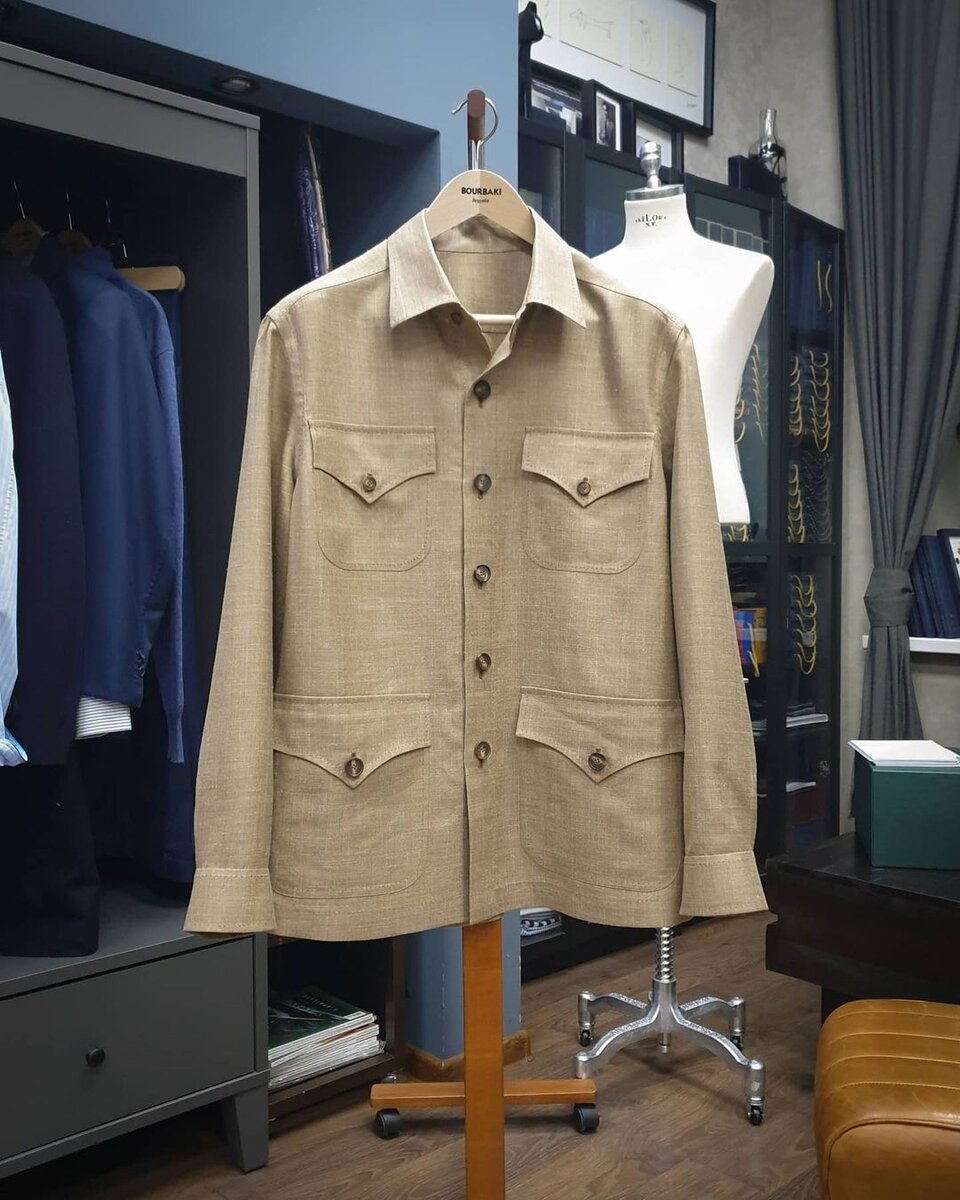 Верхняя рубашка в стиле сафари из смеси шерсти, шелка и льна от Caccioppoli в ателье Bourbaki. Коричневые роговые пуговицы и ручная вспушка в тон пуговиц прекрасно декорируют изделие.