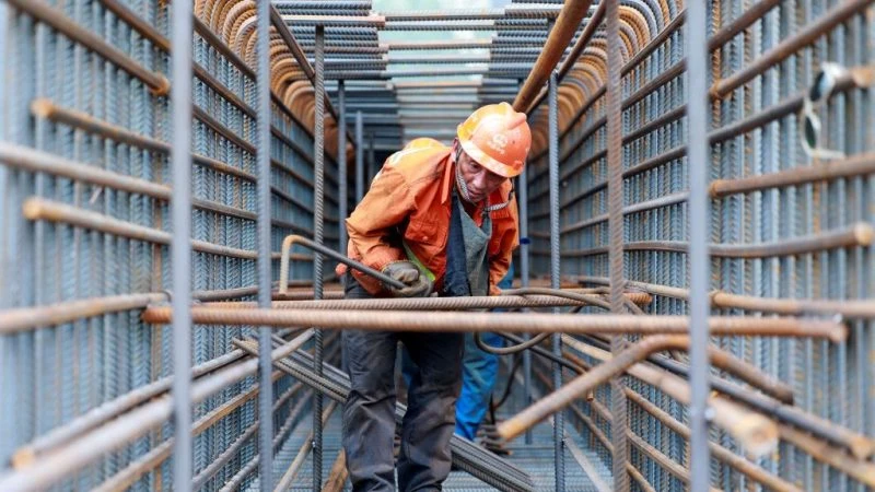 Рабочий на строительной площадке моста Чжанцзингао через реку Янцзы на острове Мачжоу в Цзинцзяне, восточная провинция Китая Цзянсу, 14 июля 2023 года. (STRINGER/AFP via Getty Images)