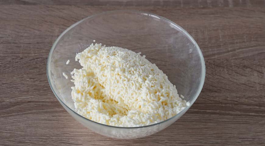 Приготовьте тесто для домашних сырников. Для этого творог протрите через частое сито в миску. Если творог слишком влажный, откиньте его на марлю, сложенную вчетверо, и отожмите.