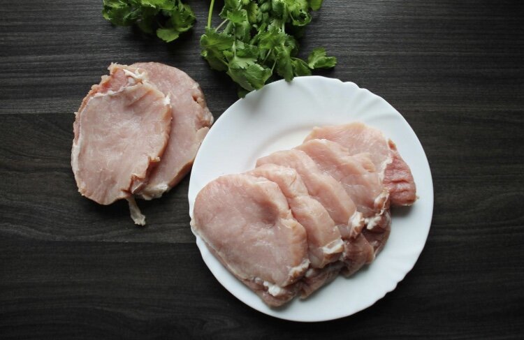 Кусок свинины вымойте под проточной водой, обсушите салфетками и нарежьте порционными кусочками толщиной около одного сантиметра.