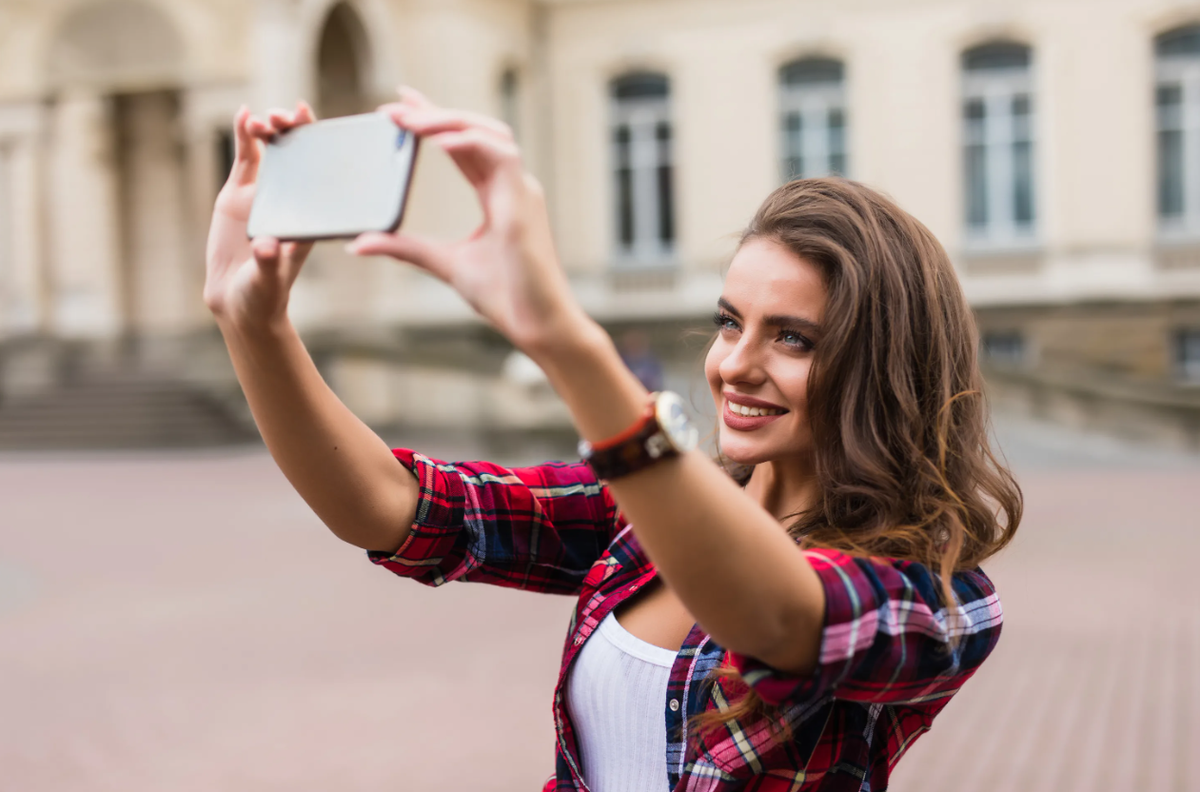 Taking photos перевод. Делает селфи. Селфи женщин с телефоном. Рука с телефоном селфи. Селфи в городе.