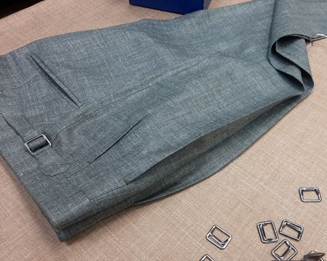 Легкие летние брюки из шерсти с шелком и льном в елочку от Caccioppoli в ателье Bourbaki. Брюки снабжены широким поясом, удлиненным переходником со скрытой застежкой, боковыми регуляторами объема и двойными защипами.