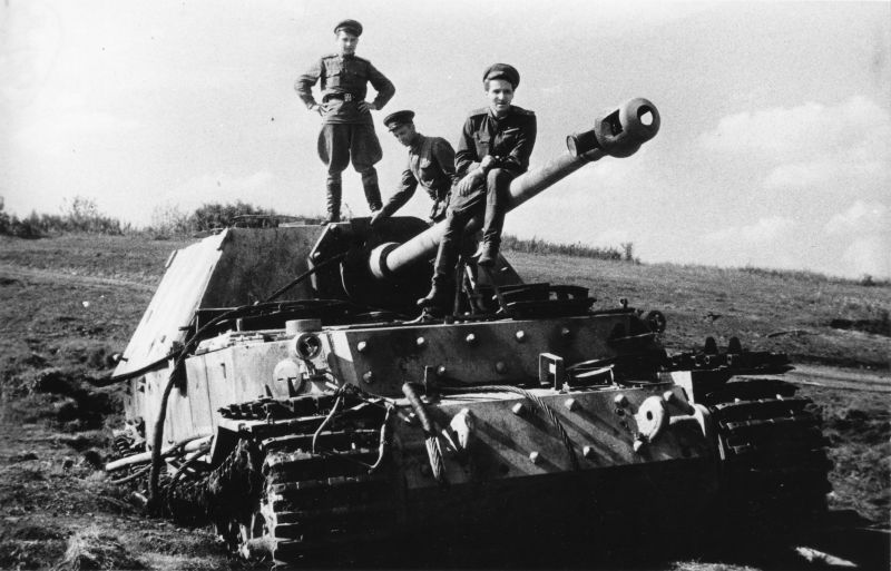 Фронтовой корреспондент Константин Михайлович Симонов сидит на стволе орудия захваченной немецкой САУ «Фердинанд», подбитой на северном фасе Курской дуги. В дульный тормоз-компенсатор орудия вставлен немецкий противогазный бачок. 