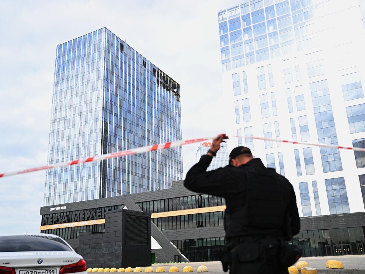    Сотрудник полиции у здания бизнес-центра на проспекте Лихачева в Москве, поврежденного беспилотником© РИА Новости / Павел Бедняков
