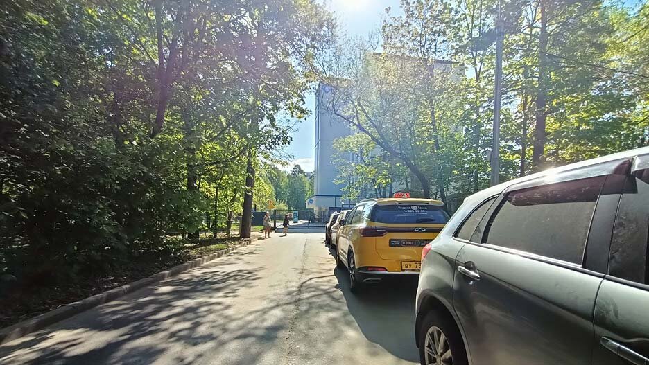 Запаркованный проезд у ворот поликлиники, май 2023