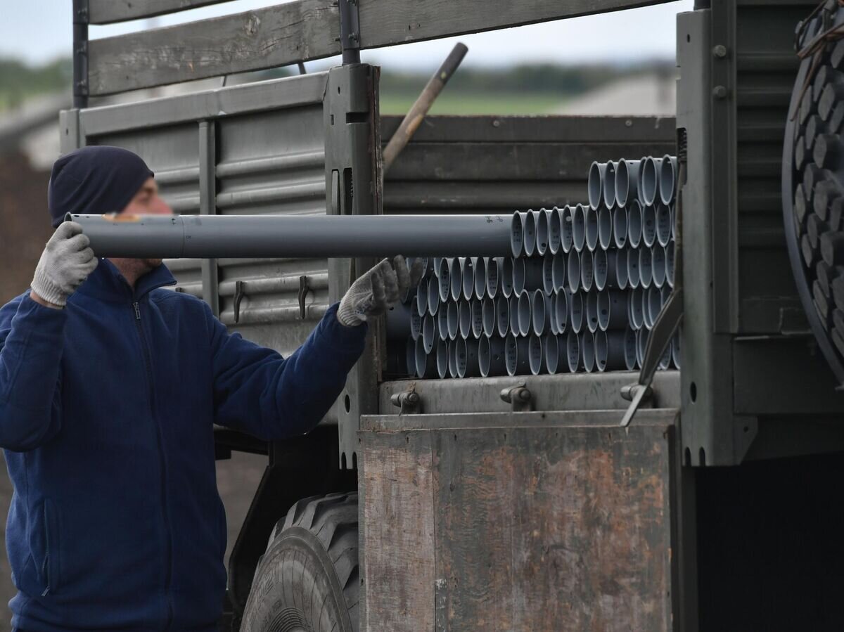    Механик разгружает грузовик с неуправляемыми авиационными ракетами (НАР) для загрузки в ударные вертолеты Ка-52 ВКС России© РИА Новости