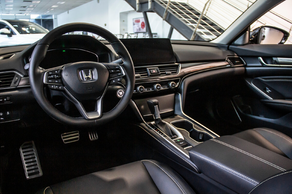 Запуск двигателя осуществляется с кнопки, на тоннеле расположен широкий подлокотник с боксом, справа от селектора КПП есть 2 глубоких подстаканника.