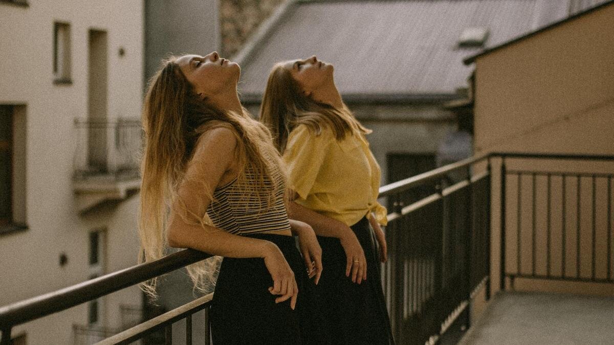    Девушки стоят на балконе, запрокинув головы вверх:Unsplash/Kinga Howard