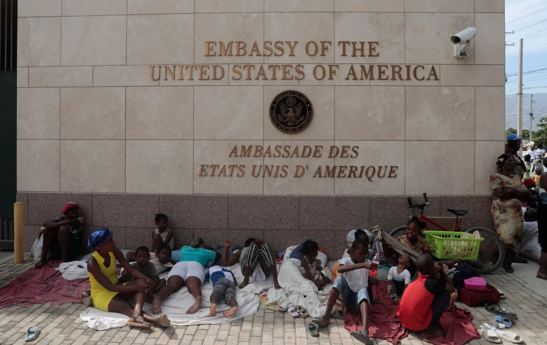 Люди, вынужденные покинуть свои дома из за вооруженных банд, нашли убежище у здания посольства США в Порт-о-Пренсе, Гаити.