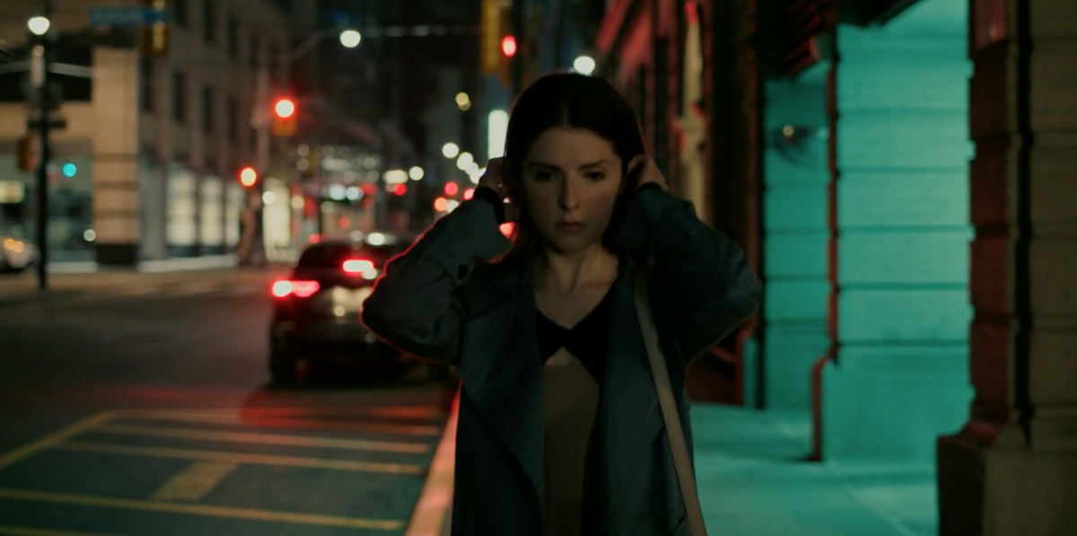 Поправляет волосы, пока идет. 