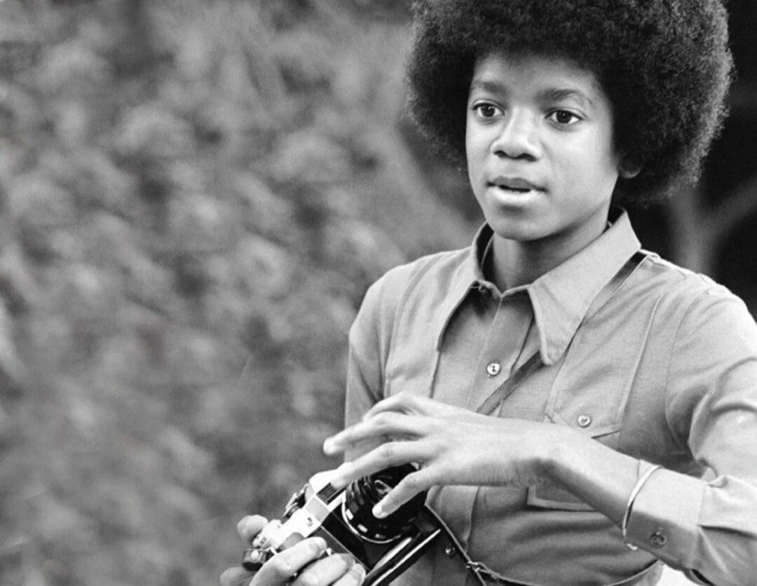 Майкл Джексон с фотоаппаратом в 1972 году.
Загадкой для последующих поколений стал вопрос о марке данного объекта. 
Советская и российская аудитория утверждает, что это точно «Зенит-Е» или «ЕМ» с характерным объективом «Гелиос-44-2».

Фото взято из открытых источников