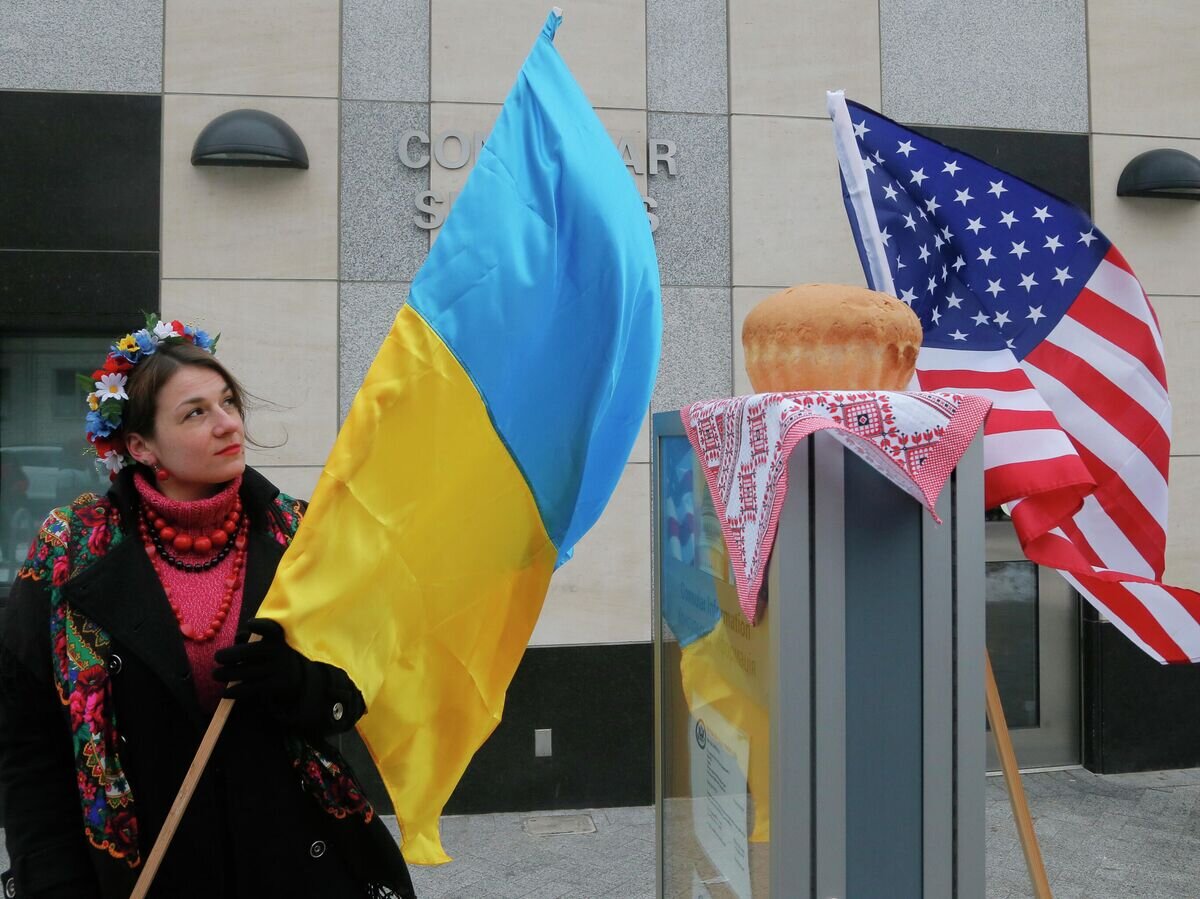    Женщина держит флаг Украины рядом с посольством США в Киеве© AP Photo / Efrem Lukatsky