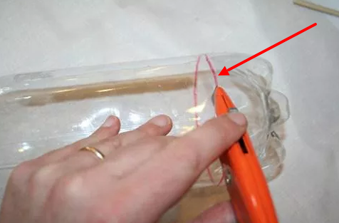 Берем нож и вырезаем дно у бутылок.