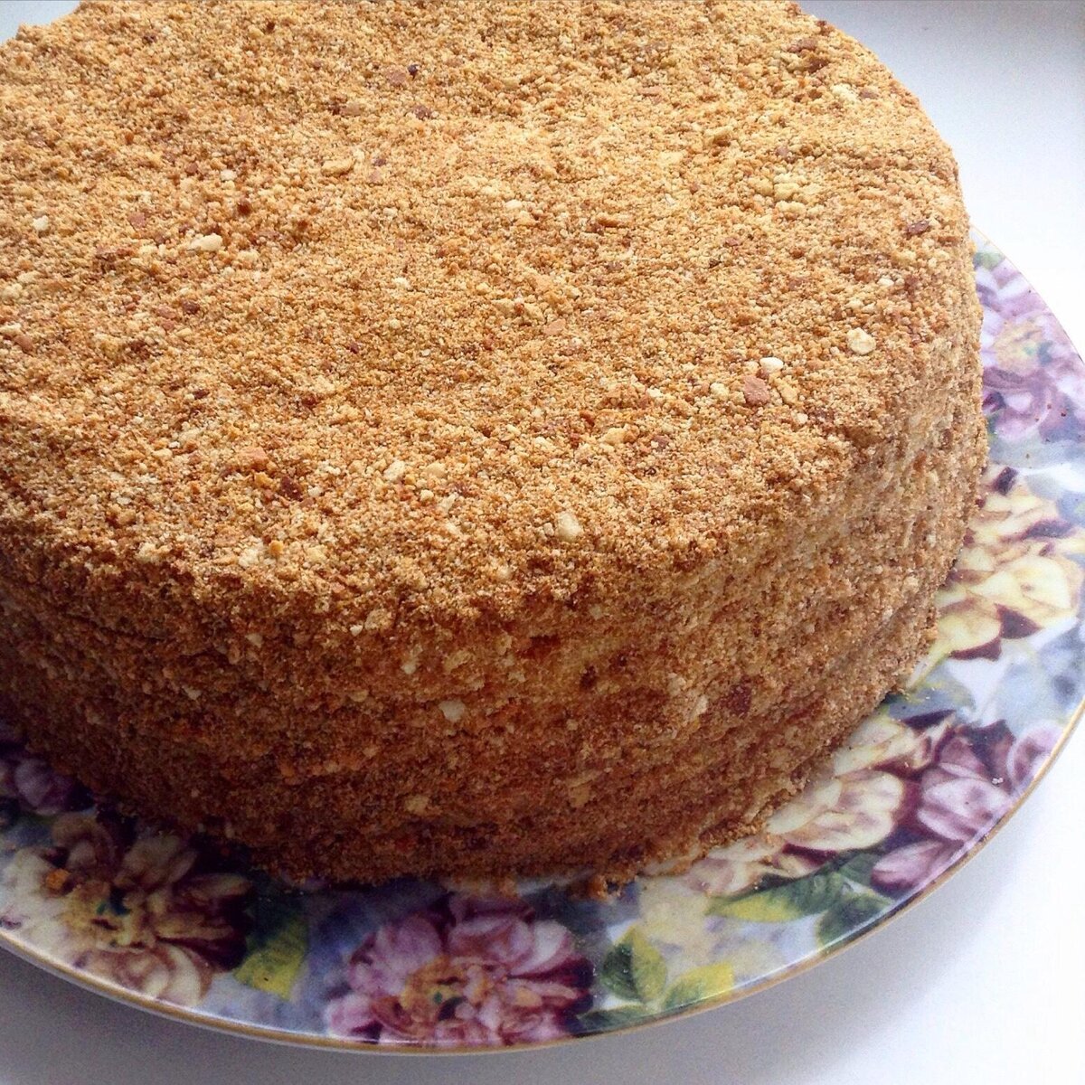 По этому рецепту торт получается очень вкусный, нежный, тающий во рту! 

* Продукты 
* Для коржей: 
Яйца - 2 шт. 
Мед - 2 ст. л. 
Сахар - 1 стакан (200-250 г) 
Мука - 3-4 стакана (500-550 г) 
Масло сливочное - 50 г 
Сода - 1 ч. л. 

* Для заварного крема: 
Молоко - 500 мл 
Яйца - 2 шт. 
Мука - 2 ст. л. (50 г) 
Сахар - 150-200 г 
Масло сливочное - 100 г 
Ванильный сахар - 1 пакетик 

* Все ингредиенты для коржа перемешиваем кроме муки и ставим на самый маленький огонь,помешивая греем пока не растворится сахар(минут 5 примерно) 
Убираем с плиты , всыпаем потихоньку муку и перемешиваем, пока не получится не липнущее к рукам мягкое тесто. Тесто делим на восемь шариков и убираем под пленкой в холодильник. 
* Приступаем к заварному крему. 
Все ингредиенты кладем в мисочку перемешиваем тщательно и тоже ставим на малый огонь,помешиваем до тех пор пока крем не загустеет(закипает!). Убираем с огня, накрываем крем пищевой пленкой(чтобы не образовалась пленка ). 
Оставляем остывать! 
* Тоненько(буквально 2мм!) раскатываем коржи и выпекаем в духовке нагретой до180 градусов по 3-5минут. 
Обрезаем готовые коржи в нужной нам форме,а обрезки затем используем ,как посыпку!(Посыпку измельчаю в блендере) 
Готовится просто и легко,получается обьедение!! 
Приятно почаевничать)))