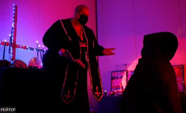 Minister Rose d'Arc проводит церемонию «раскрещивания» для посетителя в Маленькой черной часовне.    Источник Рейтер.