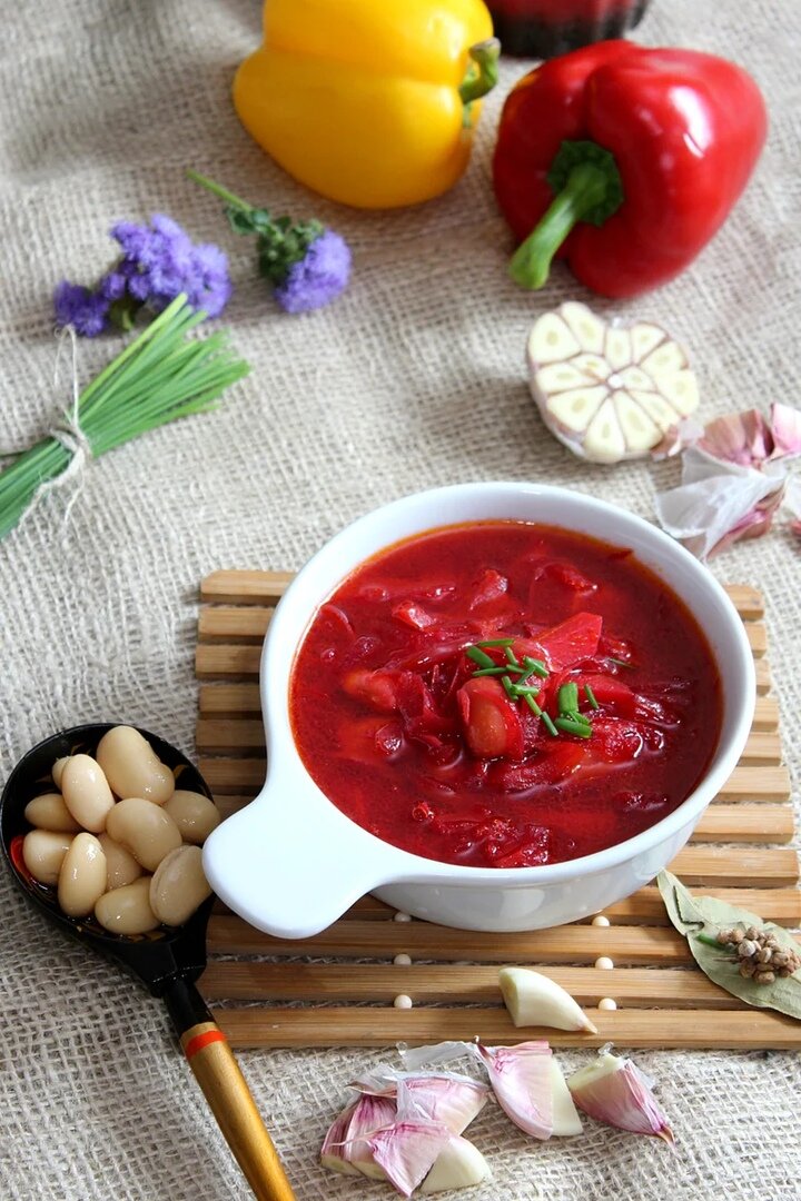 1 сладкий перец,                                                                                                                                                             2 луковицы
2 морковки
4 свеклы
1 щепотка сахара
4-5 картофелин
250 г консервированной белой фасоли
2 лавровых листа
2 ст. л. томатной пасты
2 зубчика чеснока
Соль, перец
Растительное масло для жарки
1 пучок зелени

1 Свеклу очистить и натереть на крупной терке, положить в кастрюлю и тушить на растительном масле 5-7 минут.
2 Добавить томатную пасту, сахар и соль. Затем влить ½ л горячей воды и тушить при закрытой крышке 5-7 минут.
Картофель нарезать брусочками и отправить в кастрюлю, накрыть крышкой и варить 15 минут.
3 Морковь натереть на крупной терке, лук и перец (очищенный от семян и плодоножки) нарезать соломкой и обжарить в сковороде на растительном масле до мягкости.
4 Далее в кастрюлю долить 2 л кипятка, положить поджарку, консервированную фасоль, лавровый лист, перец и соль. Готовить 5 минут, затем подавать, присыпав зеленью.

Суп получается чень насыщенный. Приготовьте обязательно. Приятного аппетита!