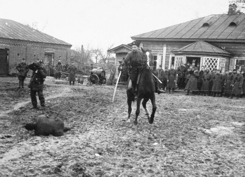 Казак-полицай на потеху венгерским оккупантам рубит шашкой пленных советских партизан. Осень 1941 года. Украина.