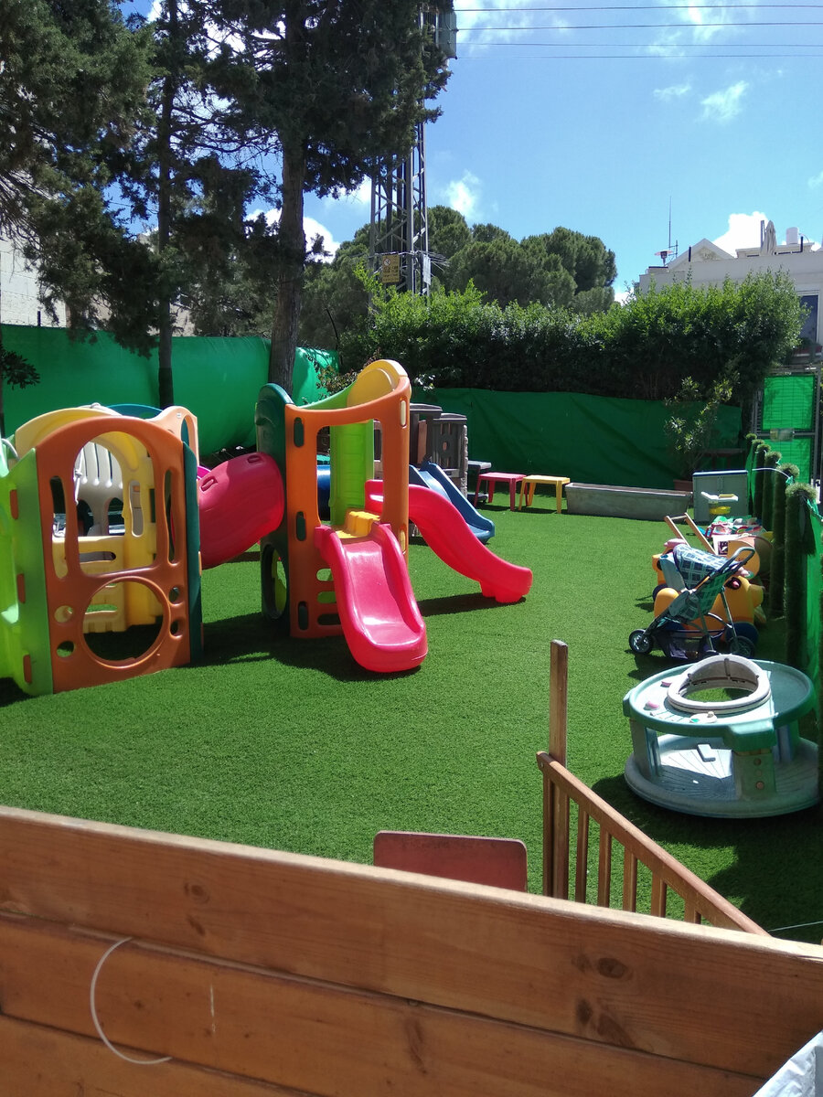 Участок средней группы. На земле - не трава, а синтетическое покрытие под траву. Подобное покрытие используется часто.