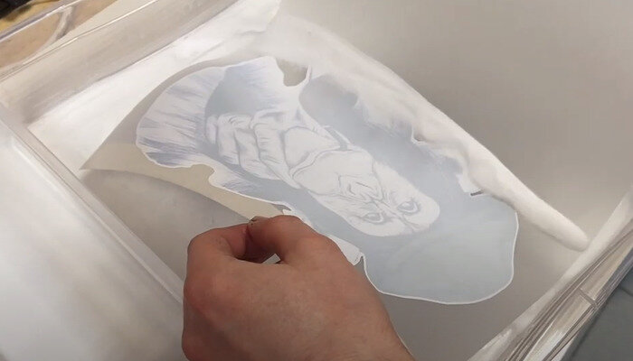 Фото 6. Лишний клеевой порошок стряхивается с изображения