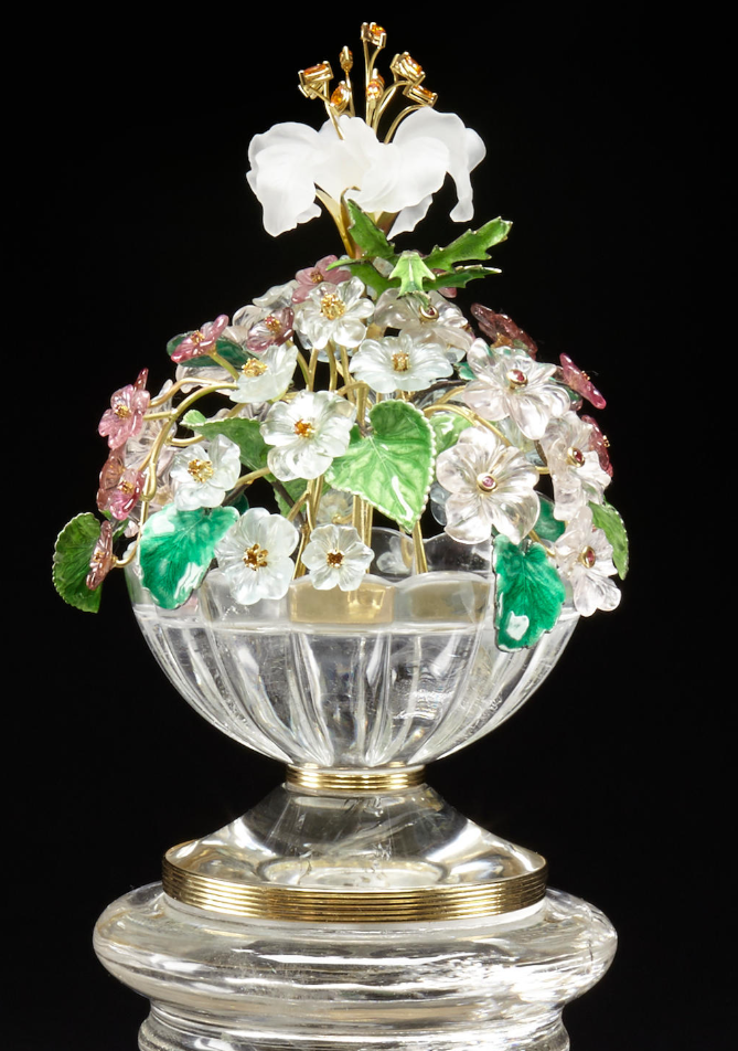 Сложный цветочный этюд, состоящий из букета из нескольких драгоценных камней, выполненного из 10 цветов морганита весом около 185,0 карата, 15 цветов аквамарина весом около 147,4 карата, 16 цветков красного турмалина весом около 48,38 карата с рубиновыми кабошонами и ограненными рубинами. и 15 мандариновых гранатов, листья зеленой эмали на серебре. Ваза из почти безупречного кварцевого горного хрусталя с рифлением и бороздками, установленная на колонне, вырезанной из кварцевого горного хрусталя, с гравированным орнаментом.