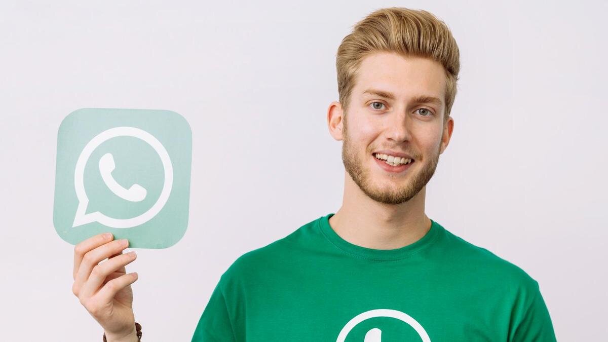    Человек держит значок WhatsApp:Freepik