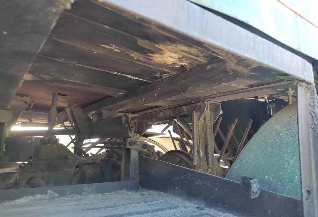 Фото читателя "Андрей Шахматов". Деревянный пол кабины, Коробка передач. Мощный рычаг переключения уходит в кабину. На БелАЗ такого не было.