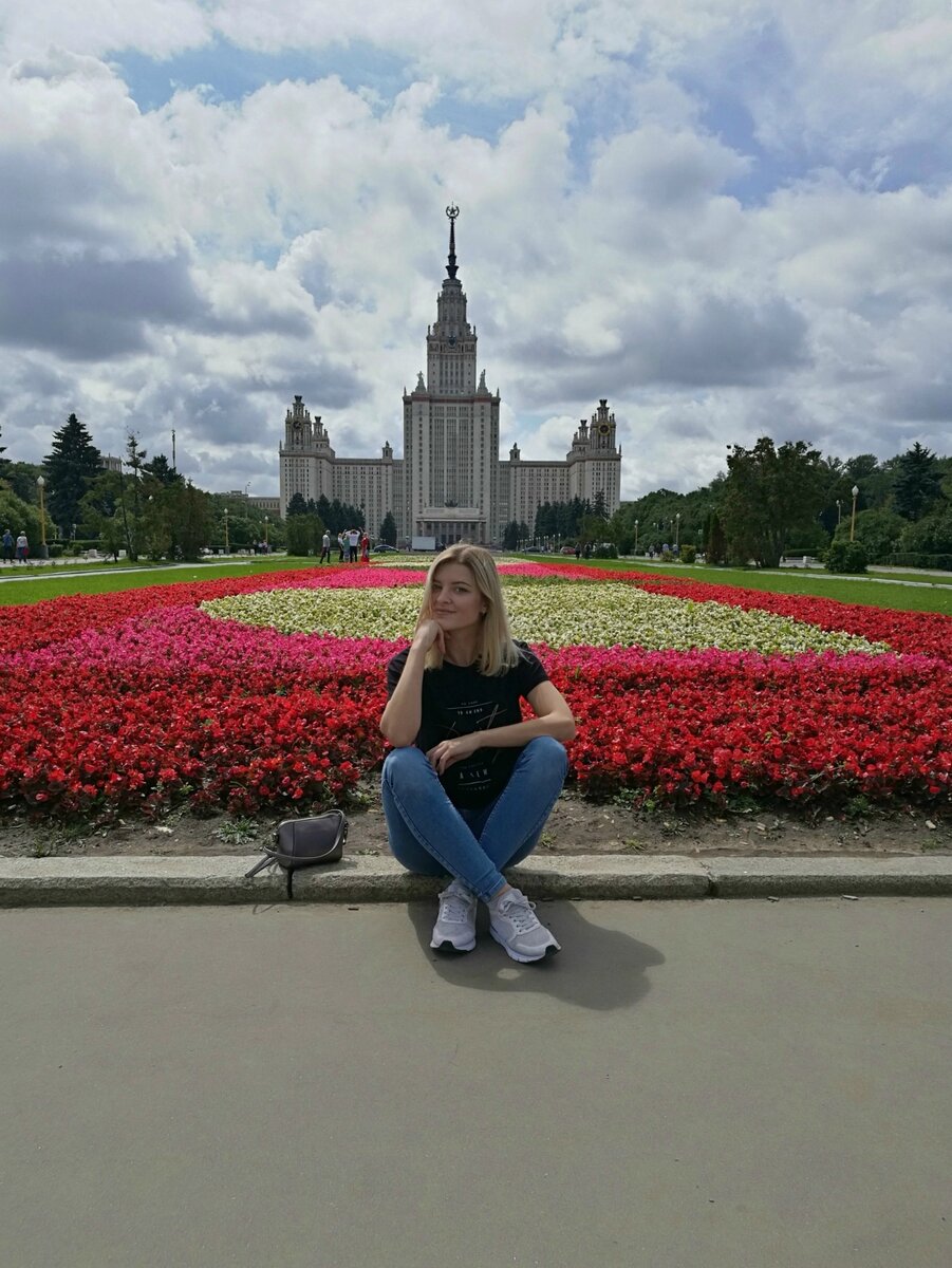 На фоне здания МГУ.