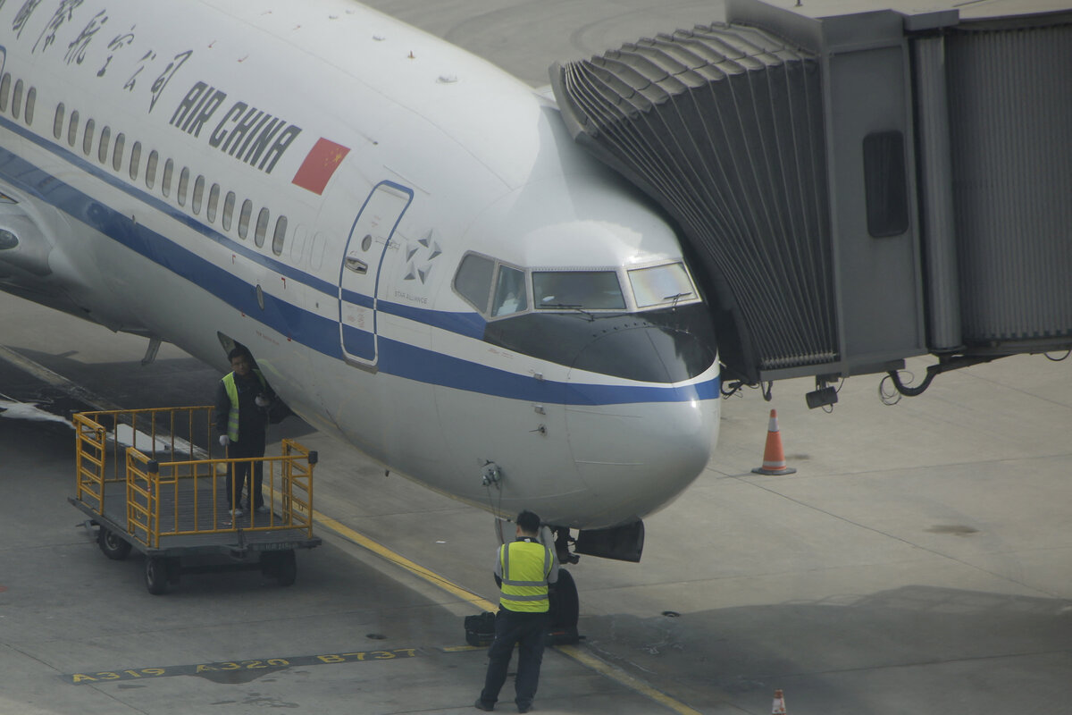 Рабочие у самолета Air China в международном аэропорту Пекин Столичный, 28 марта 2016 г. Фото: REUTERS/Kim Kyung-Hoon