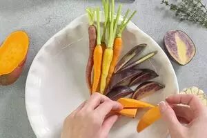 1Овощи вымыть. Батат и картофель нарезать дольками. В форму для запекания выложить молодую морковь, нарезанный батат, картофель.