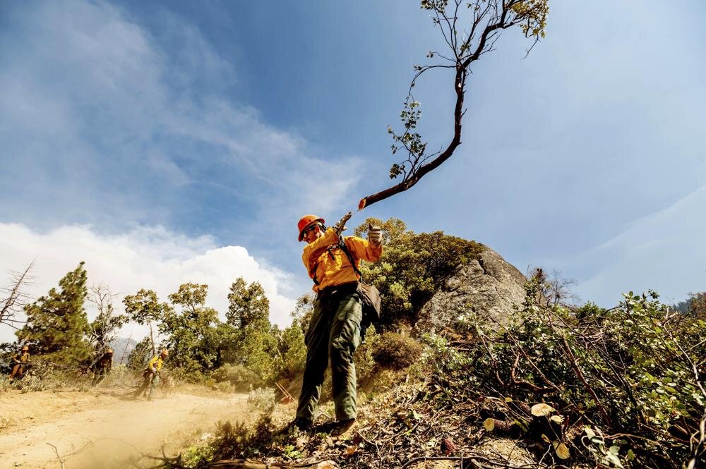 A member of the Roosevelt Hotshot Crew clears a firebreak while battling the Windy Fire on Thursday, Sept. 16, 2021, on the Tule River Reservation, Calif. His crew, which travelled from Colorado, has been battling California wildfires